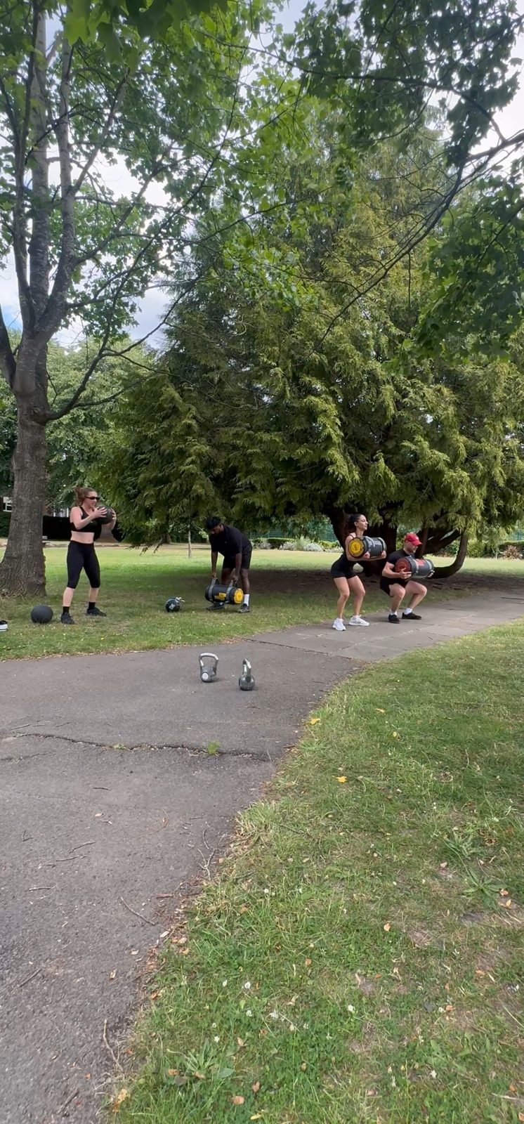 Bootcamp circuit with sandbags and medicine balls in the park